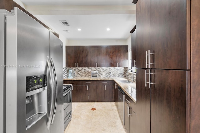 kitchen with light stone counters, dark brown cabinets, a sink, appliances with stainless steel finishes, and visible vents