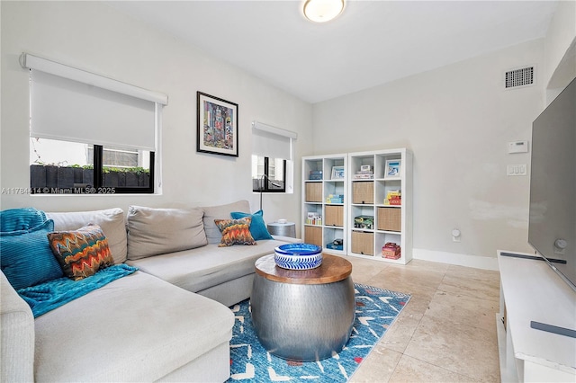 living area featuring baseboards and visible vents