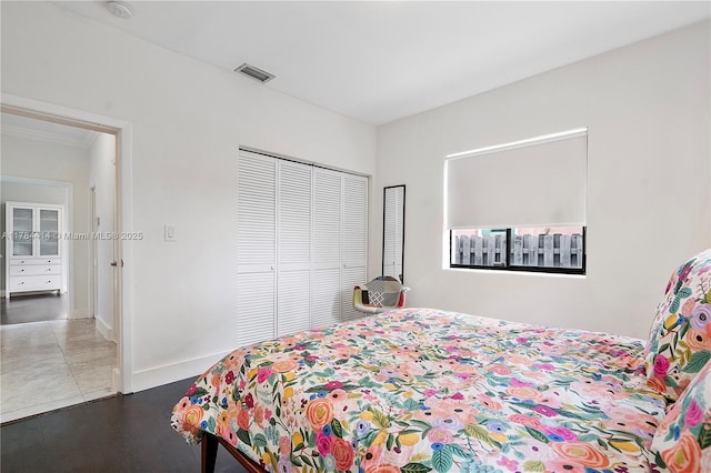 bedroom featuring baseboards, visible vents, a closet, and ornamental molding