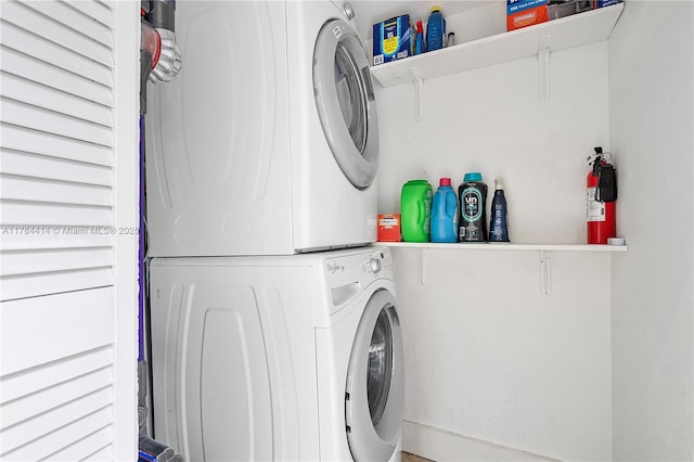 washroom featuring stacked washer / dryer and laundry area