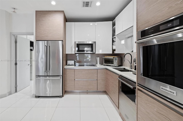 2615 NE 213th St, Miami, FL 33180 - kitchen with stainless steel appliances, modern cabinets, light countertops, light tile patterned floors, and backsplash