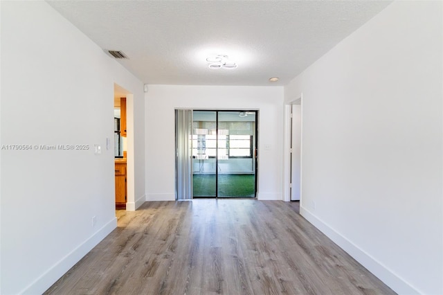 spare room featuring wood finished floors and baseboards