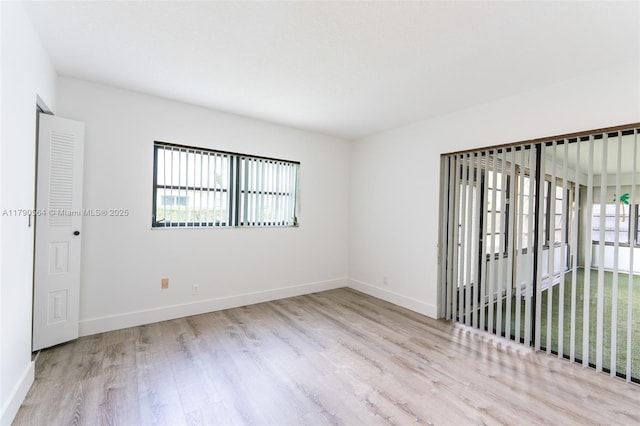unfurnished room with wood finished floors and baseboards