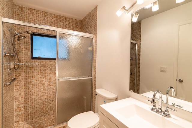bathroom with a stall shower, toilet, and vanity