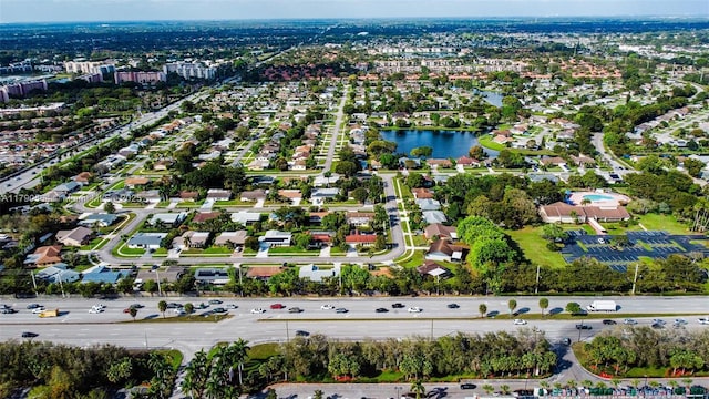 aerial view of property and surrounding area featuring a large body of water and nearby suburban area