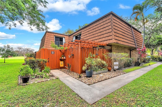 9153 SW 23rd St Unit D, Davie, FL 33324 - view of home's exterior with a lawn, brick siding, and mansard roof