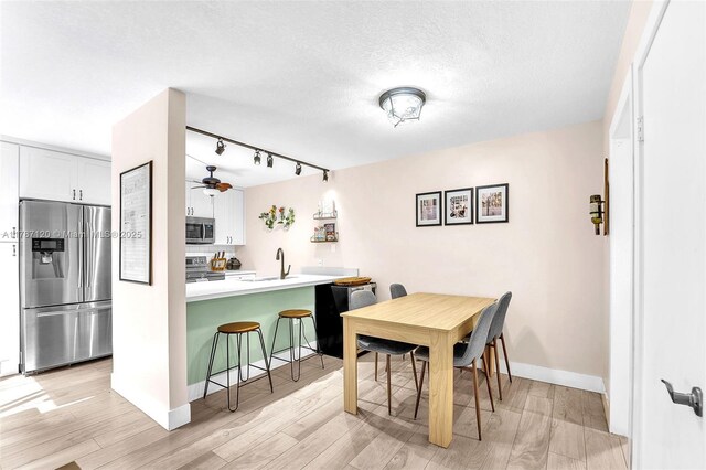 9153 SW 23rd St Unit D, Davie, FL 33324 - dining room with rail lighting, baseboards, a ceiling fan, and light wood-type flooring