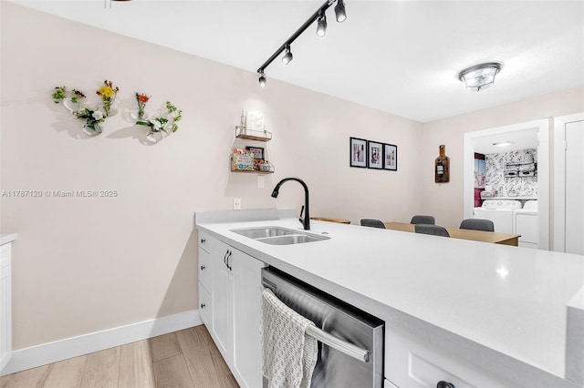 9153 SW 23rd St Unit D, Davie, FL 33324 - kitchen featuring stainless steel dishwasher, a sink, white cabinetry, separate washer and dryer, and light countertops