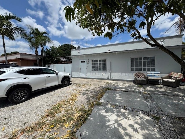 view of property exterior with a patio, stucco siding, and fence