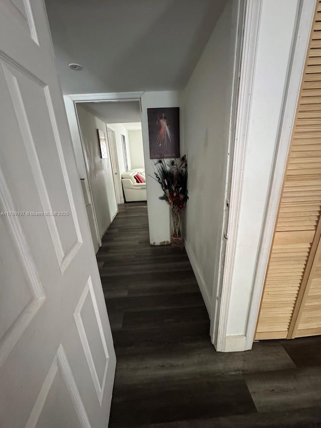 hallway with baseboards and dark wood finished floors