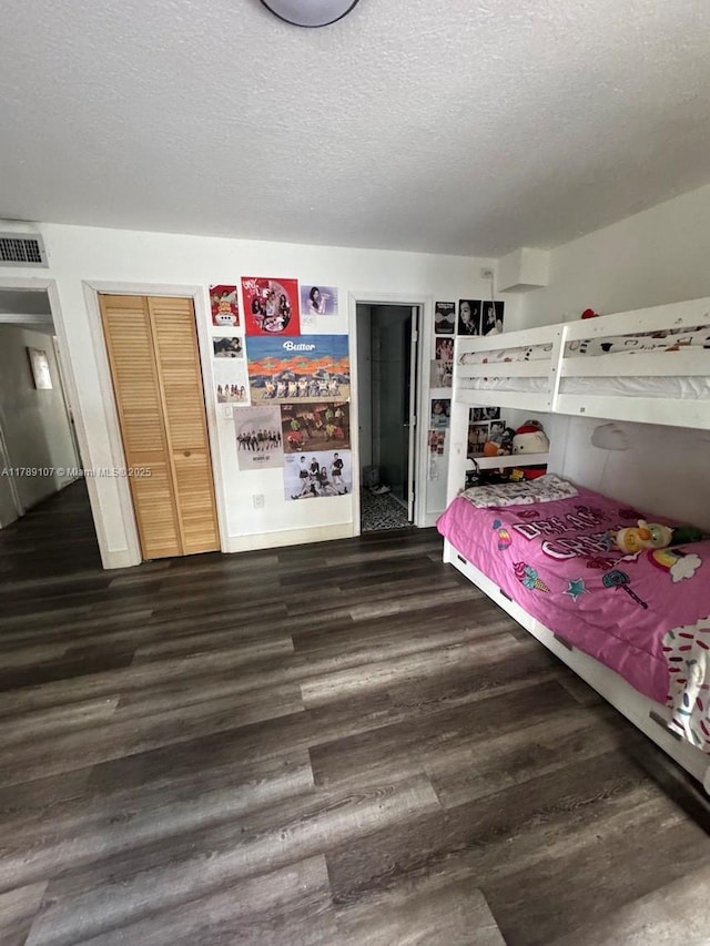 bedroom with dark wood finished floors and a textured ceiling