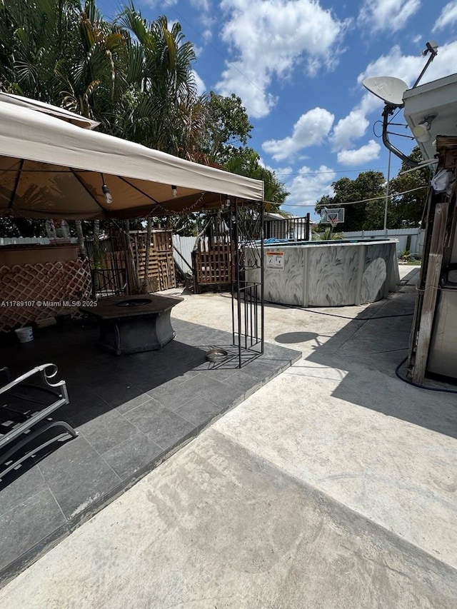 view of patio / terrace with stairway, an empty pool, and a gazebo