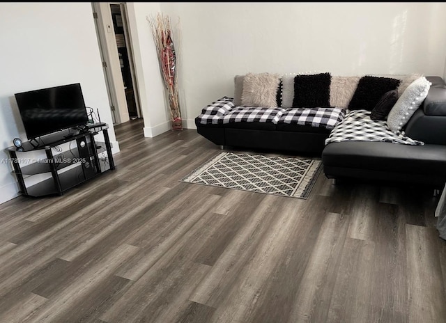 living area with baseboards and wood finished floors