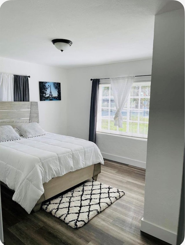 bedroom featuring wood finished floors and baseboards