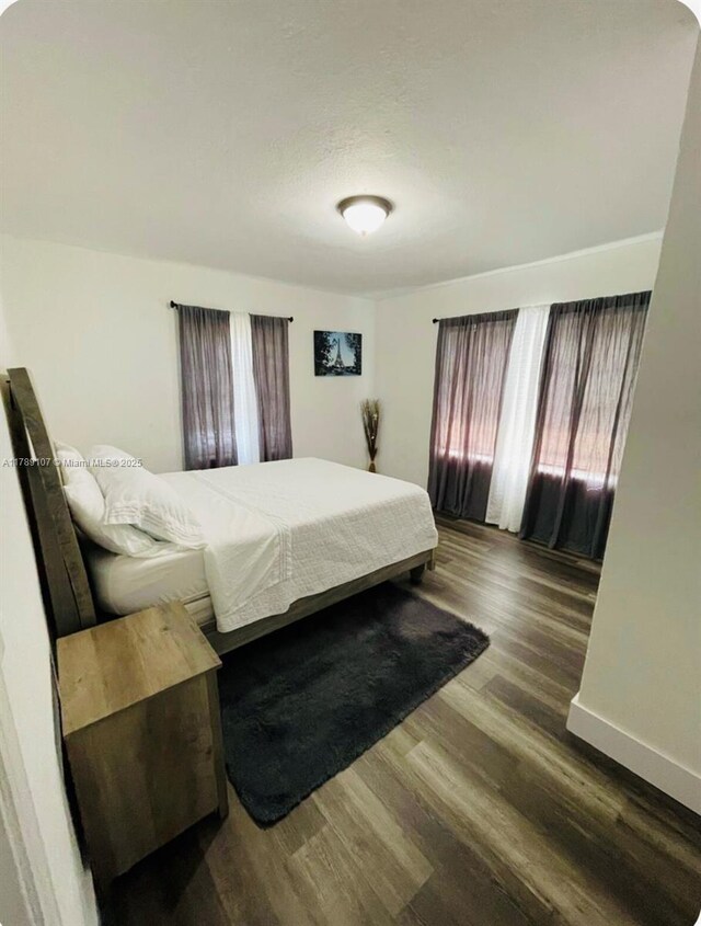 bedroom featuring baseboards and wood finished floors