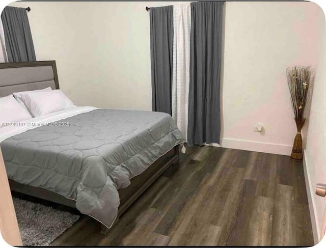 bedroom featuring wood finished floors and baseboards