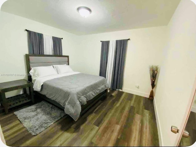 bedroom with wood finished floors and baseboards