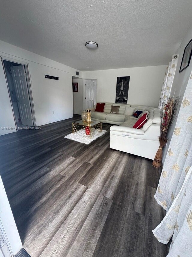 living area with a textured ceiling and wood finished floors