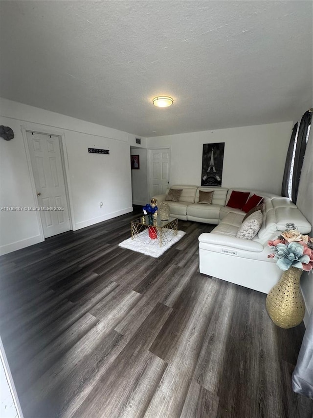 living area featuring wood finished floors, baseboards, and a textured ceiling