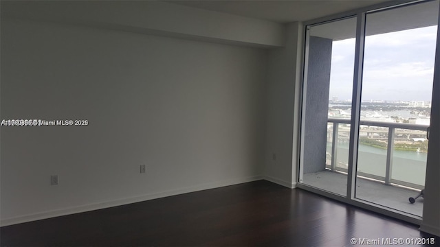 unfurnished room featuring dark wood-type flooring and expansive windows