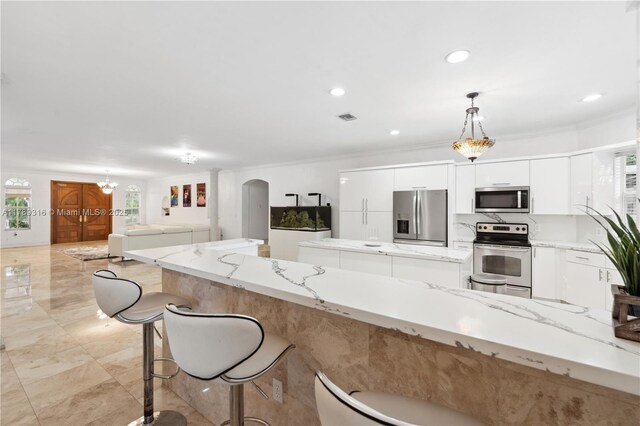 105 S Royal Poinciana Blvd, Miami Springs, FL 33166 - kitchen with arched walkways, stainless steel appliances, white cabinetry, visible vents, and pendant lighting