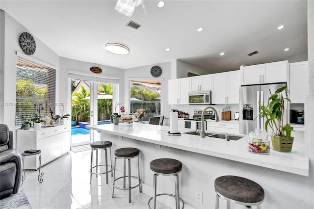 1543 NW 182nd Way, Pembroke Pines, FL 33029 - kitchen with stainless steel appliances, a kitchen breakfast bar, white cabinets, light marble finish floors, and recessed lighting
