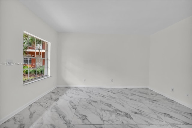 unfurnished room with baseboards and marble finish floor