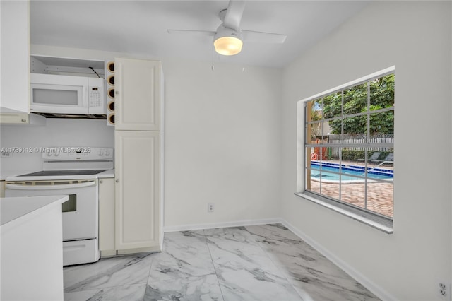kitchen featuring a healthy amount of sunlight, white appliances, light countertops, and marble finish floor