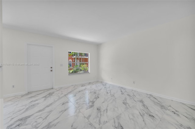 unfurnished room featuring baseboards and marble finish floor