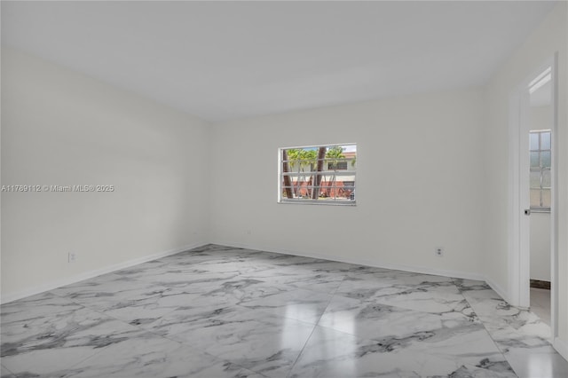 empty room featuring baseboards and marble finish floor