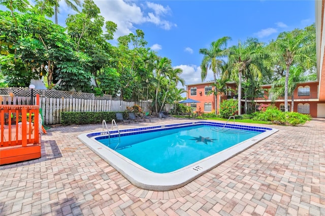 pool featuring fence and a patio area
