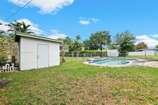 view of yard featuring a fenced in pool, an outbuilding, a shed, and a fenced backyard