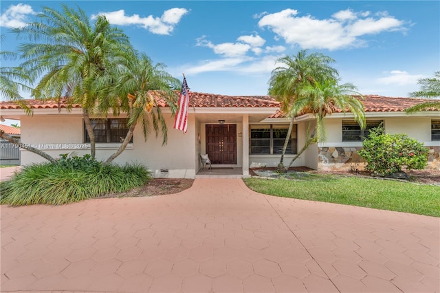 mediterranean / spanish house featuring stucco siding and a tile roof