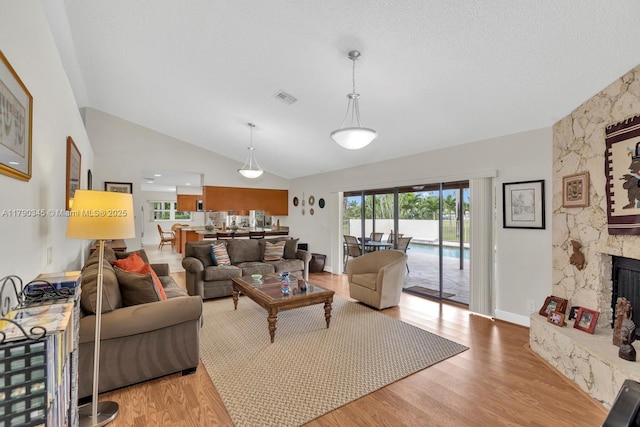 1800 NW 105th Ln, Coral Springs, FL 33071 - living room with lofted ceiling, visible vents, baseboards, wood finished floors, and a stone fireplace