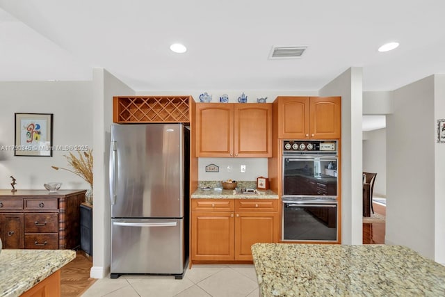 1800 NW 105th Ln, Coral Springs, FL 33071 - kitchen with light stone countertops, dobule oven black, light tile patterned flooring, visible vents, and freestanding refrigerator