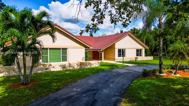1800 NW 105th Ln, Coral Springs, FL 33071 - ranch-style house featuring stucco siding, a front yard, a tiled roof, and stone siding