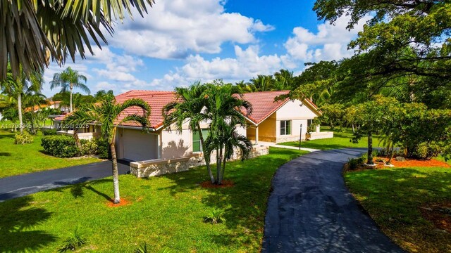 1800 NW 105th Ln, Coral Springs, FL 33071 - view of front of home with a tile roof, a front yard, a garage, driveway, and stucco siding