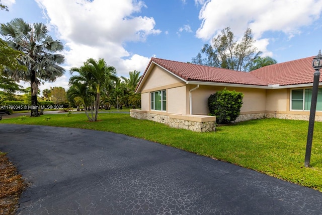 1800 NW 105th Ln, Coral Springs, FL 33071 - view of side of home featuring a tile roof, a lawn, stone siding, and stucco siding
