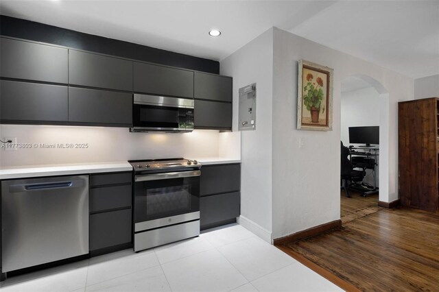 1185 Biarritz Dr, Miami Beach, FL 33141 - kitchen featuring arched walkways, modern cabinets, light countertops, and stainless steel appliances