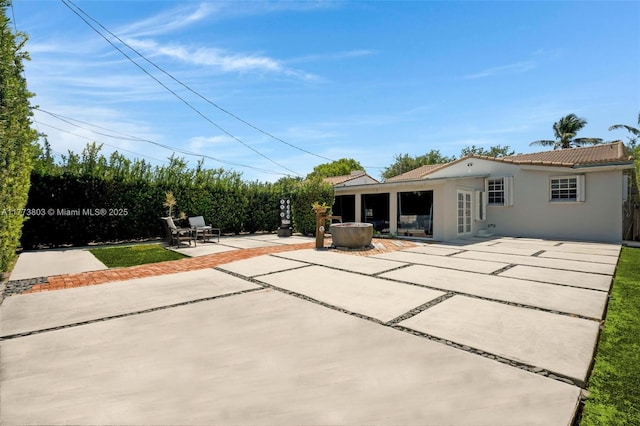 1185 Biarritz Dr, Miami Beach, FL 33141 - rear view of house featuring a patio area, a tile roof, and stucco siding