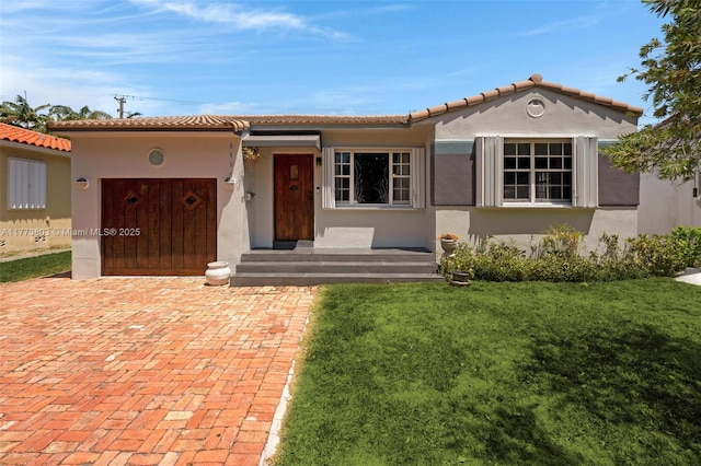 1185 Biarritz Dr, Miami Beach, FL 33141 - view of front of property featuring a front lawn, stucco siding, and a tile roof