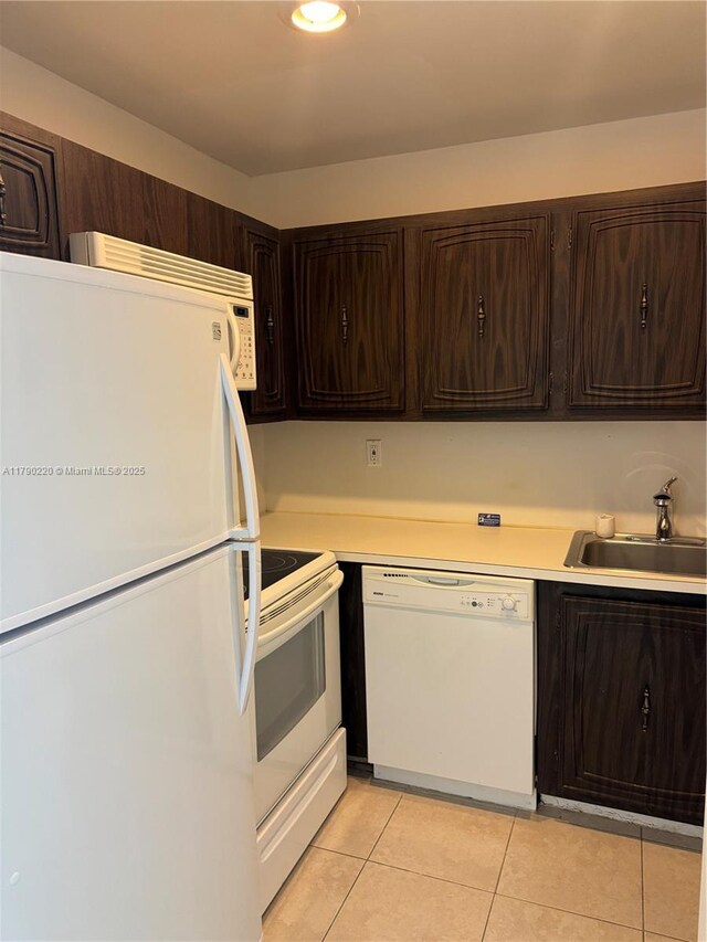 1420 Brickell Bay Dr Unit 103A1, Miami, FL 33131 - kitchen featuring light tile patterned floors, a sink, light countertops, dark brown cabinets, and white appliances