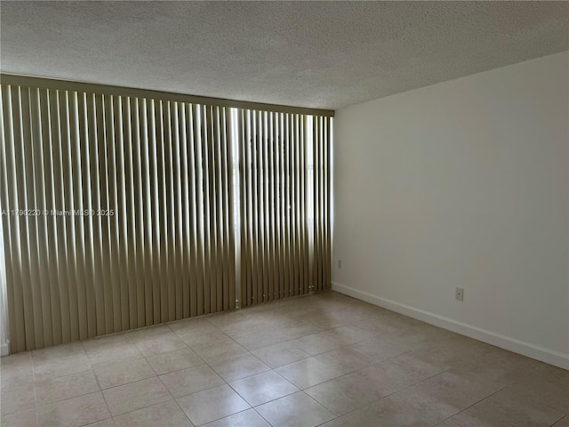1420 Brickell Bay Dr Unit 103A1, Miami, FL 33131 - empty room with baseboards, a textured ceiling, and light tile patterned flooring