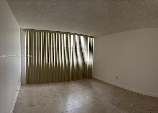 1420 Brickell Bay Dr Unit 103A1, Miami, FL 33131 - spare room featuring light tile patterned floors, a textured ceiling, and baseboards