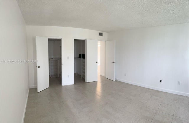 1420 Brickell Bay Dr Unit 103A1, Miami, FL 33131 - unfurnished bedroom with baseboards, visible vents, and a textured ceiling