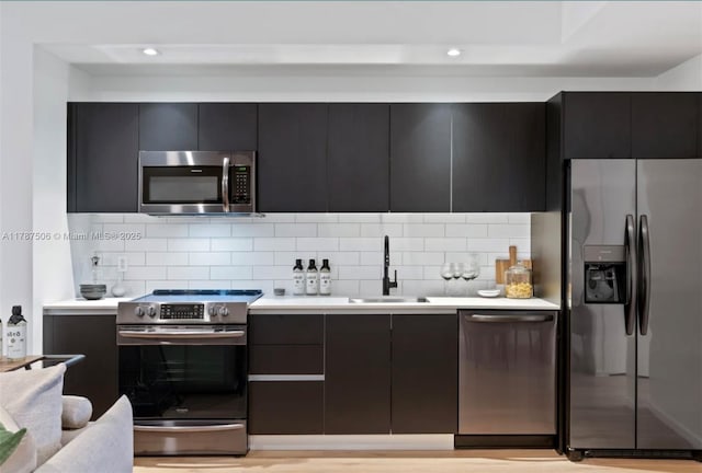 398 NE 5th St Unit 1515, Miami, FL 33132 - kitchen featuring decorative backsplash, appliances with stainless steel finishes, light countertops, a sink, and modern cabinets