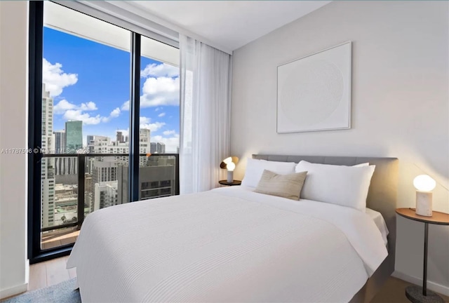 398 NE 5th St Unit 1515, Miami, FL 33132 - bedroom featuring a view of city, baseboards, wood finished floors, and a wall of windows