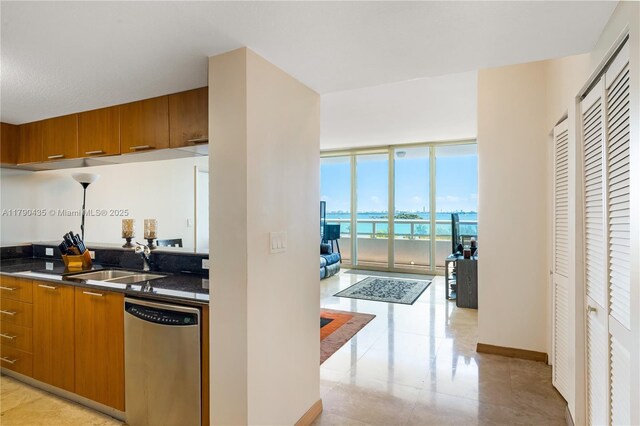 1800 N Bayshore Dr Unit 509, Miami, FL 33132 - kitchen featuring dishwasher, brown cabinetry, dark countertops, expansive windows, and a water view