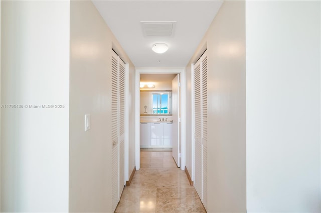 1800 N Bayshore Dr Unit 509, Miami, FL 33132 - hallway featuring light marble finish flooring and a sink