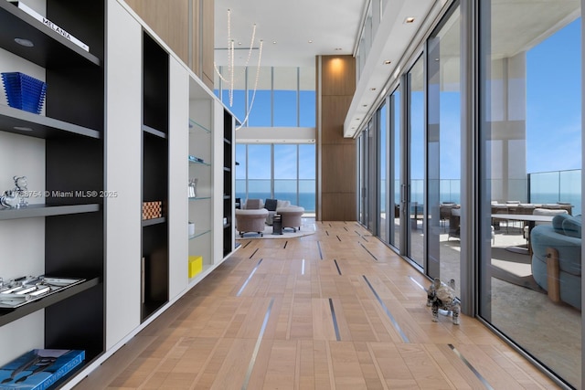 corridor featuring a high ceiling, french doors, and built in shelves